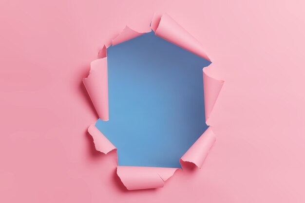 광고 콘텐츠 또는 홍보를 위해 중앙에 구멍이있는 찢어진 찢어진 분홍색 배경.