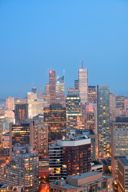 Toronto al tramonto con la luce della città e lo skyline urbano con i grattacieli