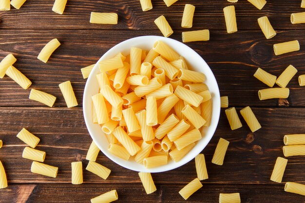 Tortiglioni pasta in a bowl flat lay on a wooden table