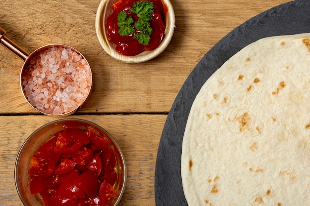 Foto gratuita tortilla vicino a pepe, sale rosa e pomodori a fette