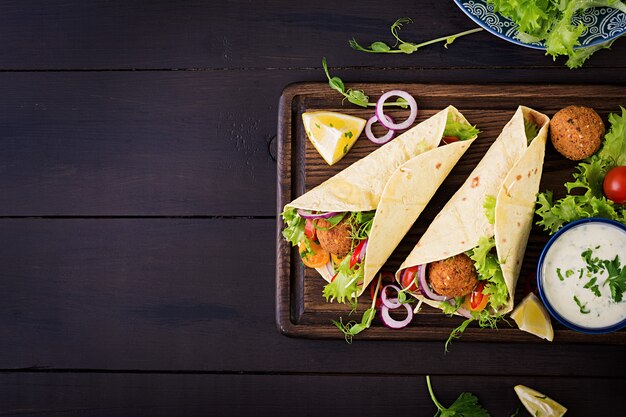 ファラフェルと新鮮なサラダのトルティーヤラップ。ビーガンタコスベジタリアンの健康食品。上面図
