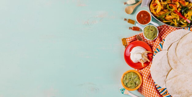 Tortillas and Mexican food on tablecloth
