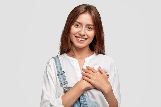 Touched stylish teenager posing against the white wall