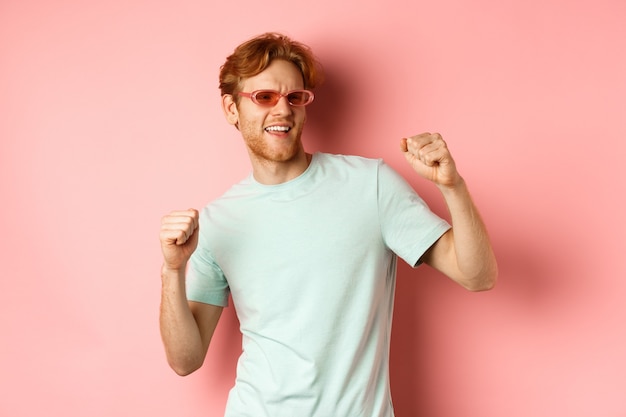 Tourism and vacation concept cheerful redhead man having fun at party dancing and enjoying holiday s...