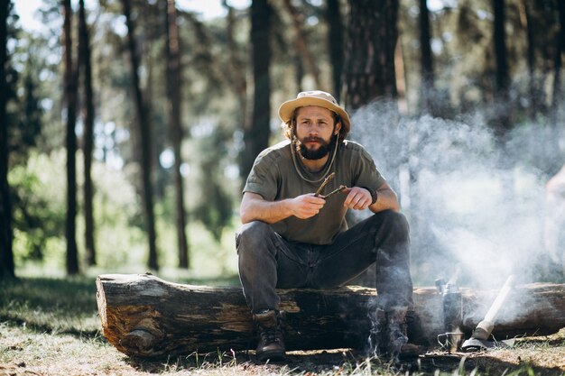 Tourist by bonfire in forest