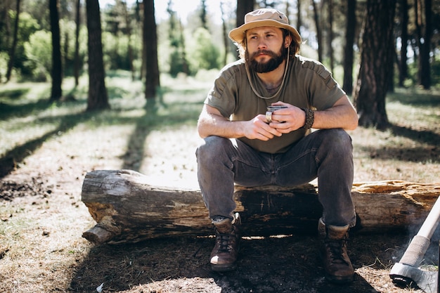 Tourist by bonfire in forest