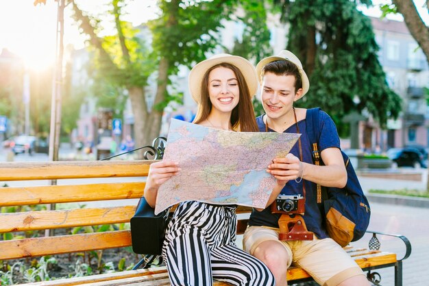 Tourist couple on bench looking at map