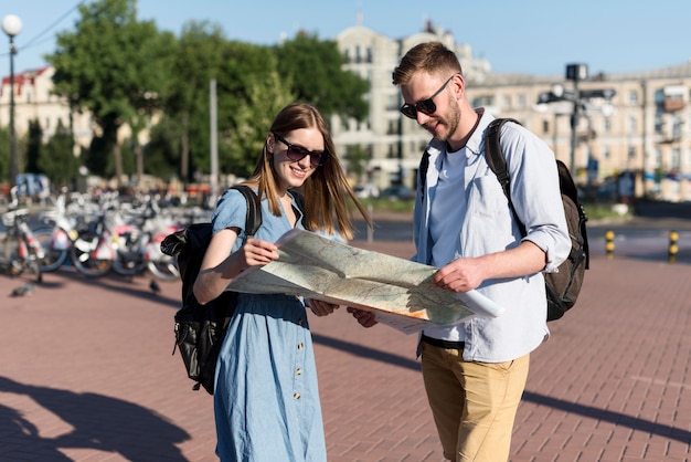 Free photo tourist couple holding map together