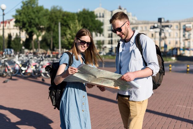 Tourist couple holding map together