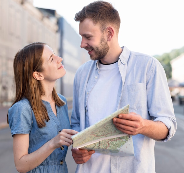 一緒に地図を保持している観光客のカップル