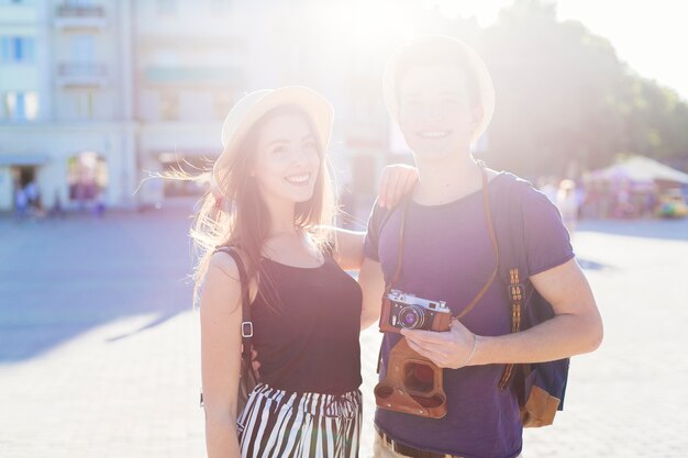 Tourist couple sightseeing in city with sun effect