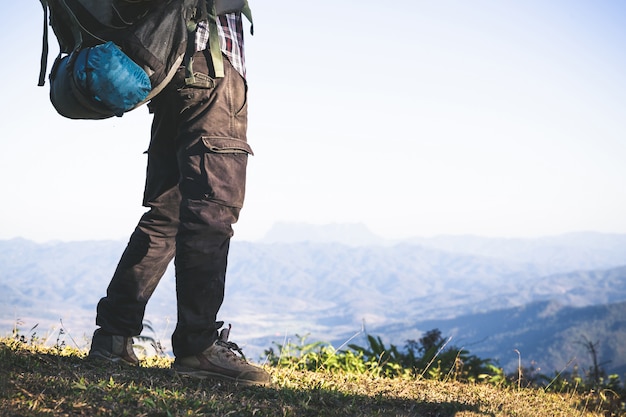 Бесплатное фото Турист с вершины горы. солнечные лучи. человек носит большой рюкзак против солнечного света