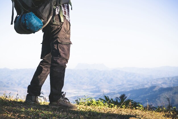 Tourist  from mountain top. sun rays. man wear big backpack against sun light