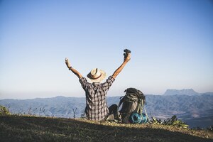 Бесплатное фото Турист с вершины горы. солнечные лучи. человек носит большой рюкзак против солнечного света