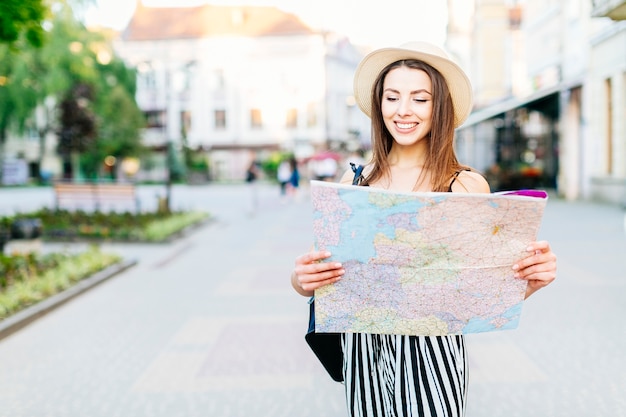 Free photo tourist girl in city with map