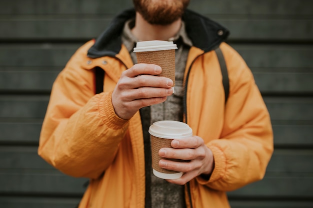 Tourist holding stacked coffee cups