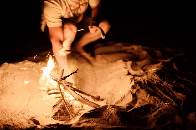 tourist makes a fire on the beach