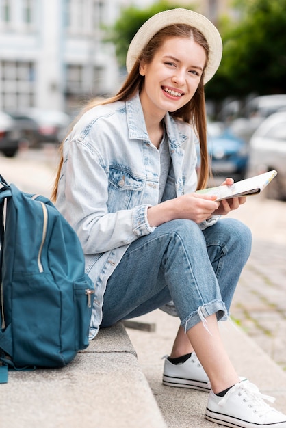 Foto gratuita turista che si siede sulle scale della città