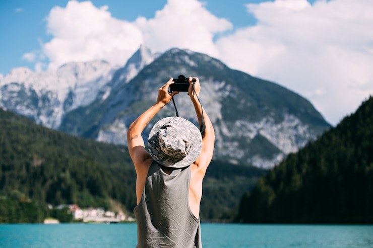Бесплатный Фотография турист, фотографирующий природный пейзаж с помощью своего смартфона