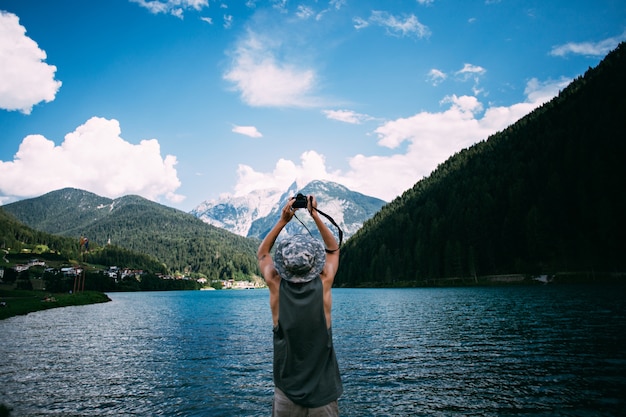 Tourist taking photos of nature landscape using his smartphone