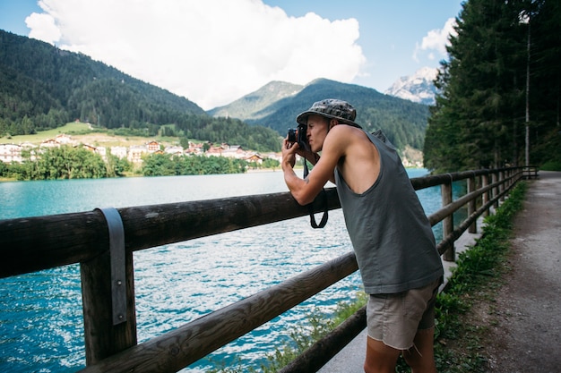 그의 스마트 폰을 사용하여 자연 풍경 사진을 찍는 관광