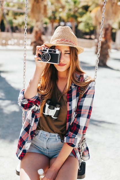 Tourist taking pictures and sitting on the swing