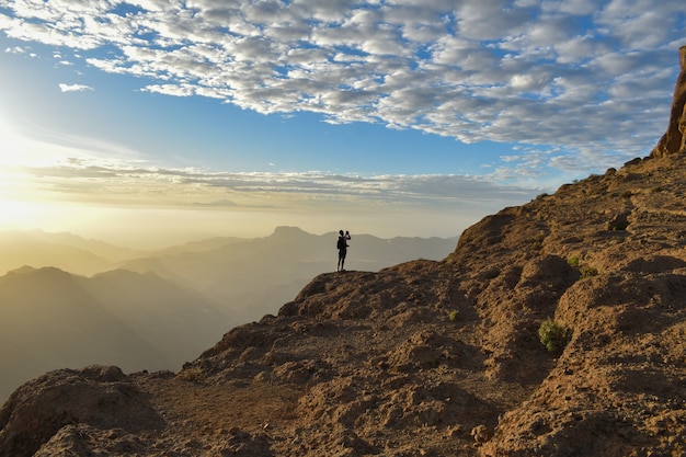 Free Photo tourist on the top of a rocky mountain in gran canaria, spain