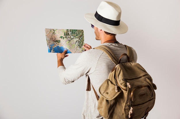 Free photo tourist with hat looking at map