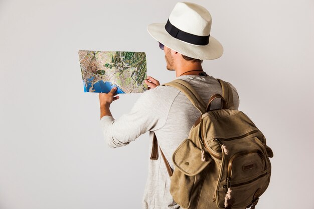 Tourist with hat looking at map