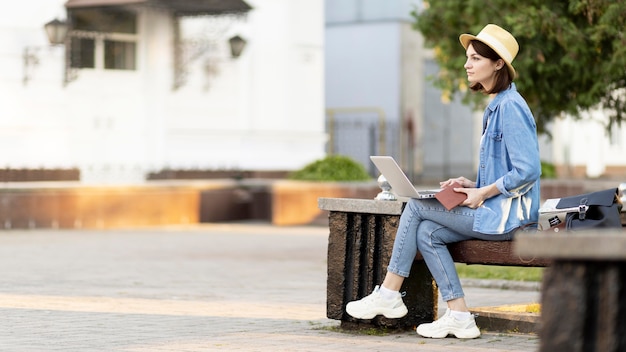 屋外のベンチに座っている帽子の観光客