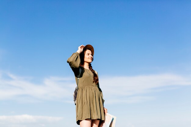 Tourist with map on sunny sky background