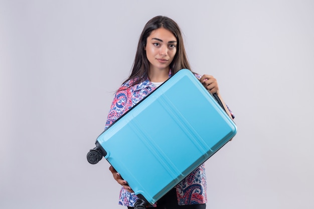 tourist woman holding travel suitcase looking confident, ready to travel concept standing on isolated white