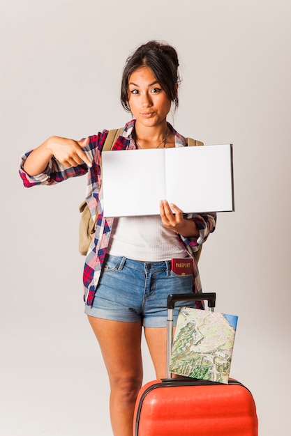 Free photo tourist woman pointing at blank book