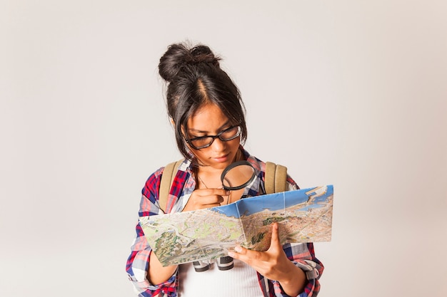 Free photo tourist woman using magnifying glass