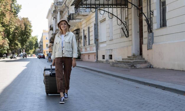 관광 여성은 유럽의 관광인 유럽 도시에서 여행가방을 들고 길을 걷습니다. 거리를 걷는다. 텍스트에 대 한 장소입니다. 공간을 복사합니다.
