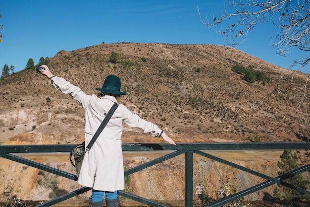 Free photo tourist woman with hands apart at handrail