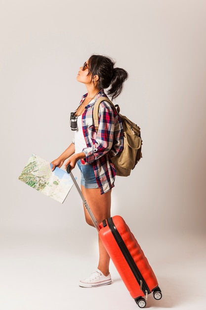 Free photo tourist woman with suitcase looking up