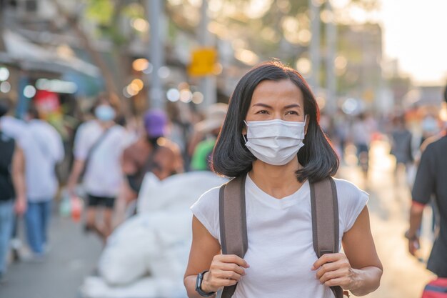 Tourists girls wearing face masks ar street.