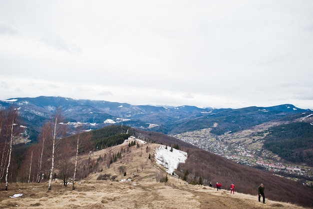 Tourists group hiking at snowy mountain valleys at Carpathian mountains View of Ukrainian Carpathians and Yaremche from the top of Makovitsa