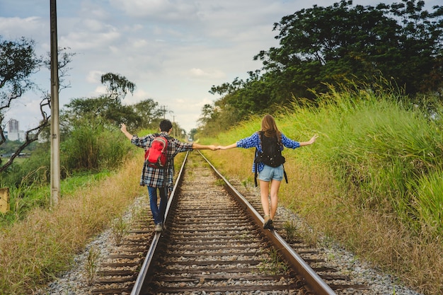 Tourists holding hands on train tracks
