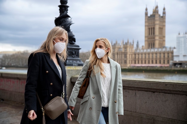 Free photo tourists visiting city and wearing travel mask