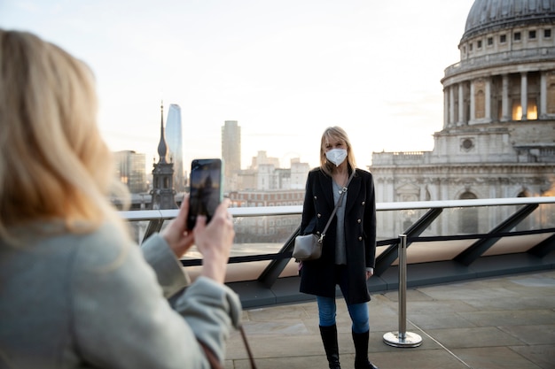 Foto gratuita turisti che visitano la città e indossano una maschera da viaggio