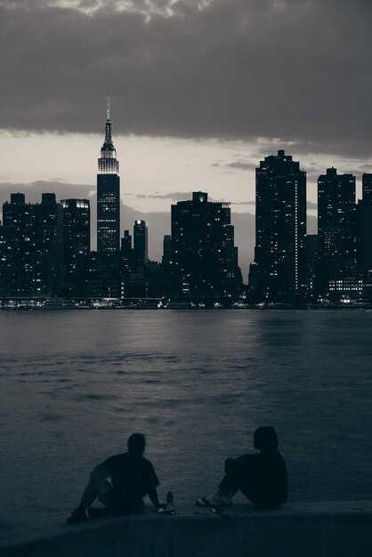 二人の男が夜にマンハッタンの景色を楽しむ