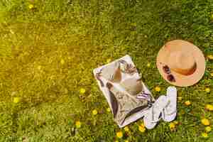 Free photo towel with bikini and summer accessories on the lawn