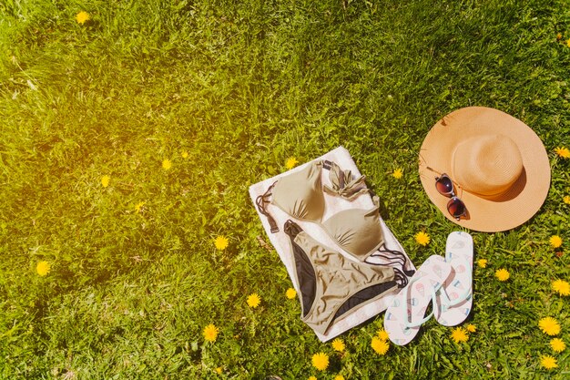 ビキニのタオルと芝生の夏のアクセサリー