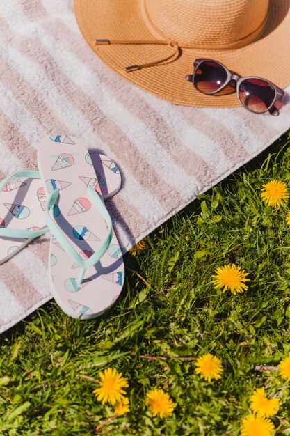 Towel with flip flops and hat with sunglasses