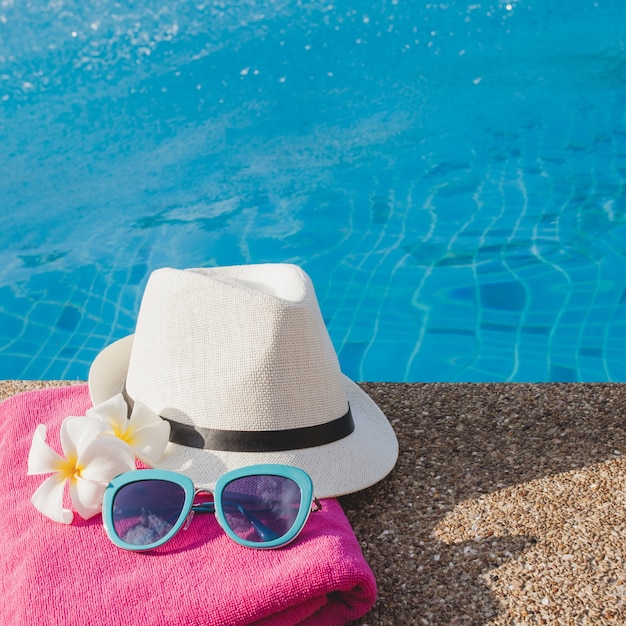 Towel with flowers, sunglasses and hat