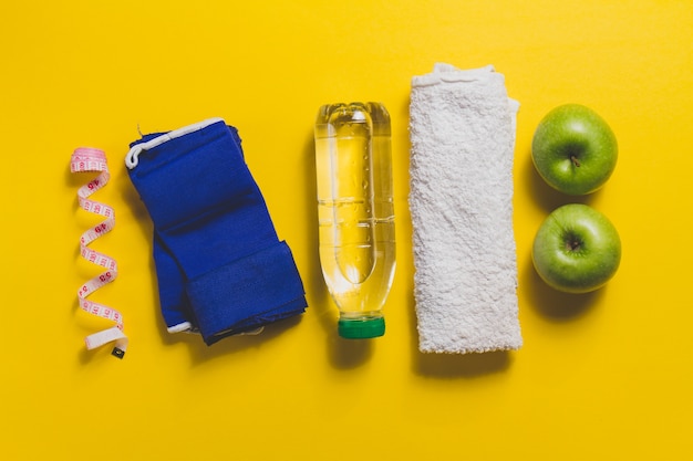 Towel with other sports accessories on yellow surface