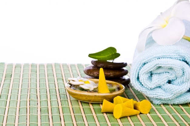 Towel with stones on a table of reeds