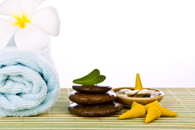 Towel with stones on a table of reeds